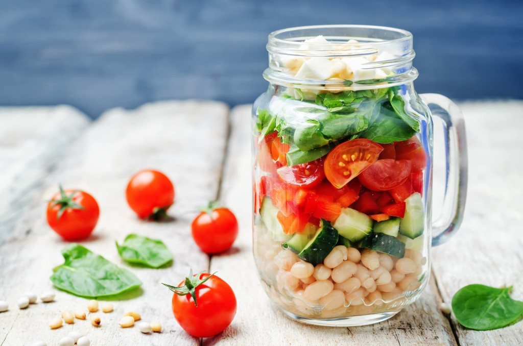 White beans cucumber tomato red pepper feta spinach salad in a jar.