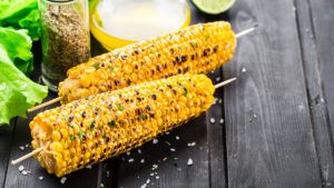 Delicious grilled corn on a wooden board