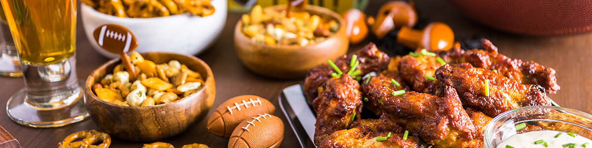 buffalo wings with assorted football game snacks on a table