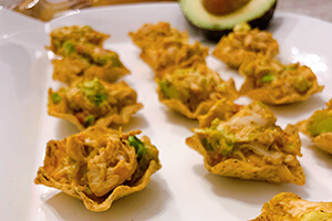 mini chicken taco cups on a plate with avocado