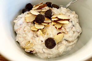 a bowl of cooked oats with almonds and chocolate chips