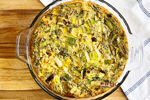 a quiche made with asparagus and leeks in a baking dish on the table