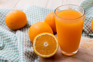 a glass of orange juice made with ginger and tumeric