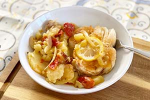 Roasted cod with potatoes and tomatoes in a bowl
