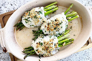 crispy flounder wrapped over asparagus in a dish