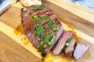 a garlic herb London Broil on a cutting board